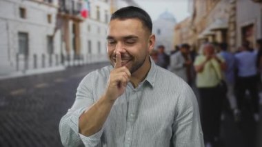 Avrupa 'nın kalabalık bir caddesinde sessiz kalmak için parmakları dudaklarına kadar uzanan adam tarihi binalar ve bulanık yayalarla dolu..