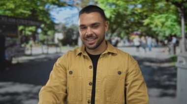 Yeşil yaprakların altında, bulanık ziyaretçilerle birlikte ormanın içindeki kamerayı gösteren insan parmağı; oyunculuk bağlantısı.