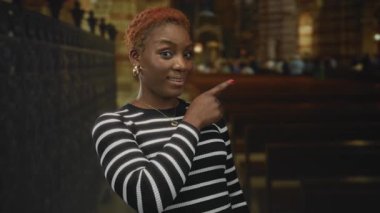 Kilisenin içindeki ahşap sıraların arasında sessiz kalmak için parmakları dudaklarına kadar uzanan çizgili kazaklı kadın..