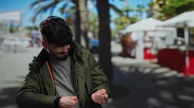 Sokakta hayali bir halatı çeken, ceketli, şehir planlı, neşeli bir şehir anını yakalayan İspanyol genç adam..