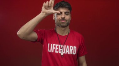 Genç cankurtaran sırıtır ve ben kırmızı gömlek giymiş alnına jest yapar ve stüdyoda ıslık; oyun güven.