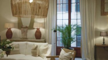 Modern dekorun, yumuşak ışıklandırmanın ve lüks yastıkların bulunduğu, rahat ve davetkar bir ortam yaratan şık bir oturma odası..