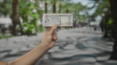 Şehir sokağında elinde kirli para tutan adam geçmişi bulanık, para birimi ve ekonomik kavramları gözler önüne seriyor..