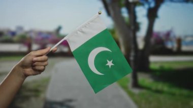 Pakistan bayrağını elinde tutan bir adam şehrin sokaklarında milli gurur anı yakalıyor..