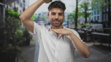 Kafasını çerçeveleyen gülümseyen bir adam. Meşgul şehir caddesinde kafeler ve ağaçlarla dolu, saf neşe..