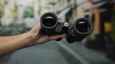 Şehrin açık hava keşfi macerasında elinde siyah dürbün tutan adam..