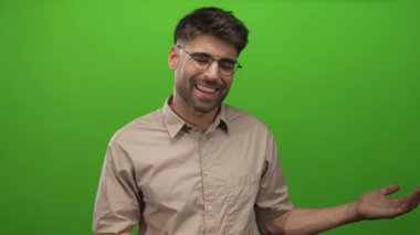 Gözlüklü ve bej gömlekli adam stüdyoda el ele tutuşuyor; açıklık merakı nişanı hoş geldiniz.