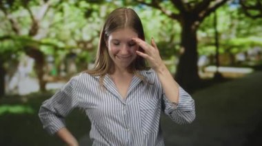 Kadın, ormandaki tapınağa rahat bir duruş ve yumuşak bir gülümsemeyle dokunur. Etrafı yemyeşil yapraklarla çevriliyken. Huzur..