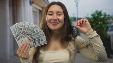 Güler yüzlü genç İspanyol kadın şehir merkezinde güneşli bir sokakta bize dolar hayranı ve araba anahtarı tutuyor..