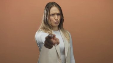 Genç kadın jestleri, izole edilmiş kahverengi duvar arkaplanına karşı eliyle buraya gelir. Davetiye ya da eylem bildirir.