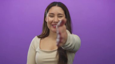 Kadın parlak bir gülümseme ve mor stüdyo ortamında doğrudan göz teması ile el sıkışmak için elini uzatır; güven teması bağlantısına hoş geldin arkadaşlık sıcaklığı açıklık birliği samimiyeti.