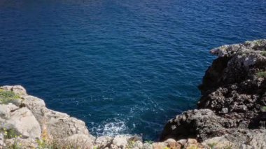 Mallorca kıyıları berrak mavi su ve güneş ışığı altındaki kayalık uçurumları gösteriyor. Seyahat ve doğa temaları için mükemmel..