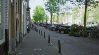 Bulanık Avrupa şehir caddesi. Arka planda dağılmış bisiklet arabaları ağaçlar ve tarihi binalar. Açık hava kentsel bokeh sahnesi yaratıyor..