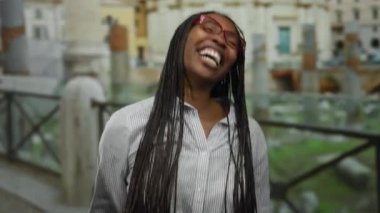 Roma 'daki manzaralı Roma harabelerinin önünde güvenle gülümseyen kadın, tarihi mekanın güzel özünü yakalıyor..