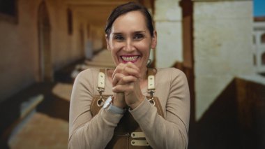 Eski kasaba sokaklarında önlük giymiş gülümseyen bir kadın kültürel bir şehir ortamında mutluluk ve mesleği anlatan neşeli ve çekici bir ifade sergiliyor..