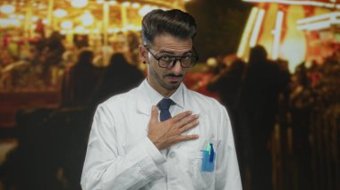 Gözlük takan ve laboratuvar önlüğü giyen bilim adamı gece yarısı açık ışıkların ortasında sandık başında duruyor..