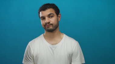 Sakallı ve yüzü yukarı doğru eğilmiş bir adam ve mavi stüdyoya bakan gözler; tefekkür.