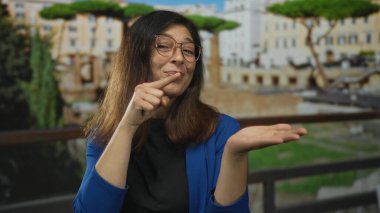 Gülümseyen ve parmaklarıyla eski Roma binasını işaret eden kadın, açıklığı hoş karşılıyor..