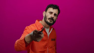 Turuncu hapishane tulumlu İspanyol adam pembe arka planda bıçak tutuyor, tehlike ve gerilim yaratıyor..