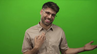 Gözlüklü ve bej gömlekli adam stüdyoda el ele tutuşuyor; açıklık merakı nişanı hoş geldiniz.