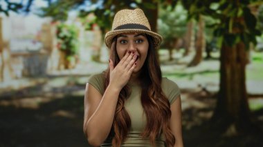 Uzun saçlı İspanyol kadın güneşli bir açık hava parkında gülümsüyor..