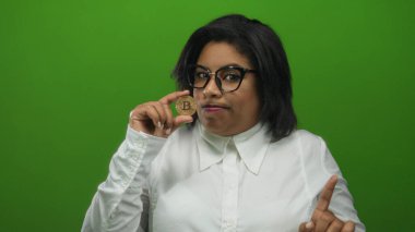 Bitcoin 'i canlı yeşil zemine karşı kendinden emin ifadeyle tutan kadın, kripto para birimi eğilimi ve dijital finans alanında kadın yetkilendirmesini vurguluyor.