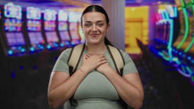 Kumarhanede kumar makinelerinin keyfini çıkaran genç bir kadın aydınlık bir ortamda heyecan ve enerji dolu bir anı yakalıyor..