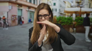 Bulanık yayalarla dolu kalabalık şehir caddesinde el kol hareketi yapan genç kadın, hayal kırıklığını durdurdu.