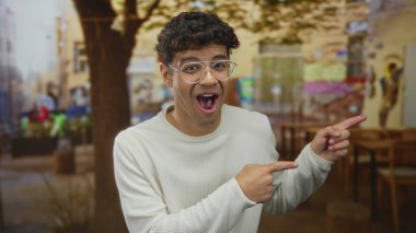 Ahşap masalar ve bulanık lokantalarla teras inşaatında iki işaret parmağı da sağdaki adamı işaret ediyor. Sürpriz tepki..