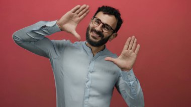 Sakallı İspanyol bir adam. Yüzü elleri kıpkırmızı, gözlüklü, mavi gömlekli, yaratıcı ve odaklı bir duruş sergiliyor..