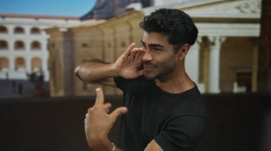 Eli ağızda olan genç İspanyol adam binanın önünde bağırıyor; heyecan anonsu..