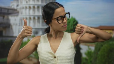 İkonik sidik kulesinin önünde karışık duygular ifade eden genç bir kadın İtalya 'da açık havada bir yansıma anı yakalıyor..