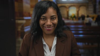 Kadın yüzü kahkahalarla gülüyor göğsünde ve kafasında eller geriye atılmış, gözleri kapalı ve ağzı açık kilisenin içinde yumuşak ışık altında; neşe.