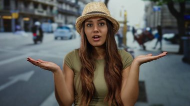 Canlı şehir caddesinde kameraya bakan kadın, gün ışığında şaşırmış bir ifade takınıyor..