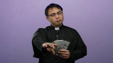 Gözlüklü ve papaz tasmalı bir adam mor bir arkaplan karşısında dolarları tutuyor. Dini bir bağlamda el kol hareketi yapıyor, parayı vurguluyor..