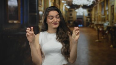 Büyük müze binasında resimlerle dolu parmakları olan bir kadın, alaycı alaycılık şüpheciliğiyle tırnak işareti yapıyor..