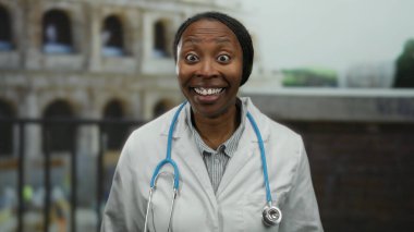 İtalya 'da Roma Kolezyumu' nun önünde steteskopla gülümseyen, beyaz önlüklü, açık hava ortamında sağlık ve turizm temalı bir doktor kadın..