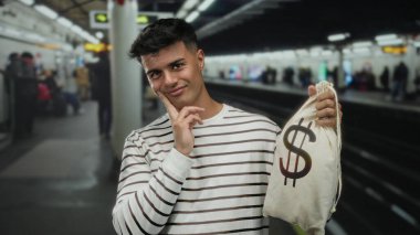 Tren istasyonunda elinde dolar işareti olan bir çanta taşıyan genç adam, arka planda banliyö sakinleri bulanıklaşırken düşünceli görünüyor, erkek portresi ve finans teması üzerine odaklanmış şehir içi sahneleri yaratıyor.