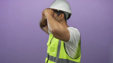 Beyaz kasklı adam mühendis el dürbünü yapıyor ve stüdyoda yansıtıcı yelek giyiyor..