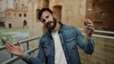 Eski Roma 'da sakallı İspanyol bir adam. Kot ceket giyiyor. Tarihi tuğla mimarisine karşı.