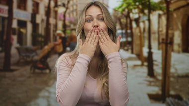 Pembe kazaklı kadın kaldırım taşı caddesinde avuçlarıyla öpüşüyor..