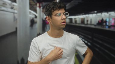 Meşgul bir tren istasyonunda, metro peronunda göğsüne yakın beyaz gömleğini ayarlayan elleri olan bir adam..