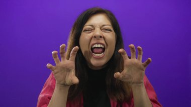 Orta yaşlı, pembe ceketli, pençeli ve mor dişli bir kadın..