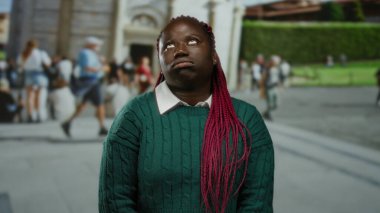 Pembe örgülü kadın İtalya 'daki sidik kulesinin önünde poz veriyor, turistlerle ve arka planda tarihi mimariyle huzurlu bir anı yakalıyor..