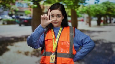 Turuncu yelekli kadın sokak gösterisinde ezik jestler yapıyor esmer saçlı ve şehirli gönüllü iş yapıyor..