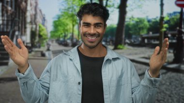 Genç İspanyol asıllı gülümseyen adam, yoğun şehir caddesinde büyük ölçümler için ellerini açar; güven açıklığı.