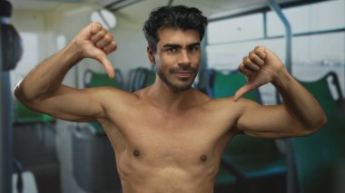 Tişörtsüz İspanyol genç adam göğsünde baş parmakları açık şekilde otobüsün iç koltuğunda oturuyor. Onaylanmıyor..