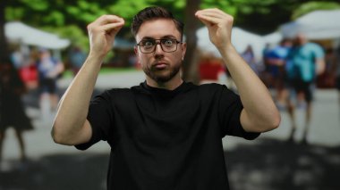 Sakallı ve gözlüklü genç adam hareketli bir şehir caddesinde hareketli, hareketli şehir ortamına karışıyor, bulanık hareketli figürlerle çevrili..