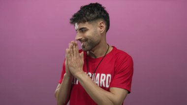 Nazikçe gülümseyen ve pembe stüdyoda el ele tutuşan İspanyol bir cankurtaran..