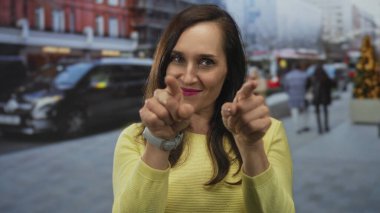 Latin kökenli genç bir kadın şehir sokaklarında dudaklarıyla öpüşüyor..